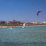 "Hurghada, Egypt - December 10, 2012: Recreational pursuit on the beach by the Red Sea in Hurghada, Egypt. Tourists kitesurfing, windsurfing and sunbathing on the beach"